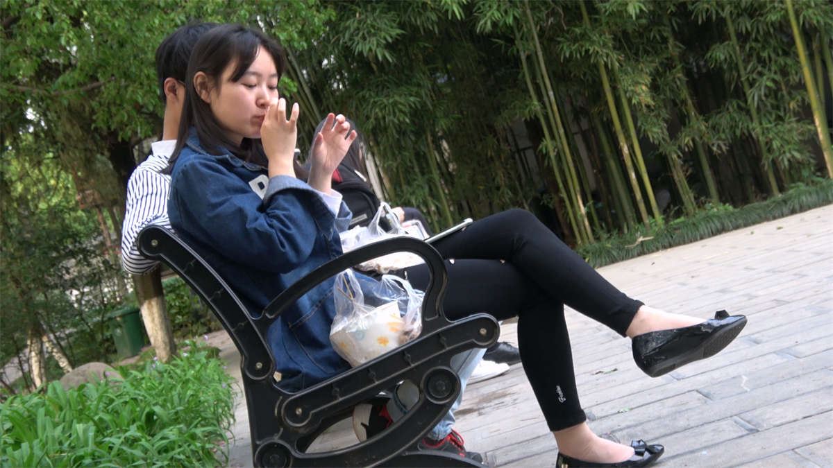 坐在凳子上吃东西的肉丝美足