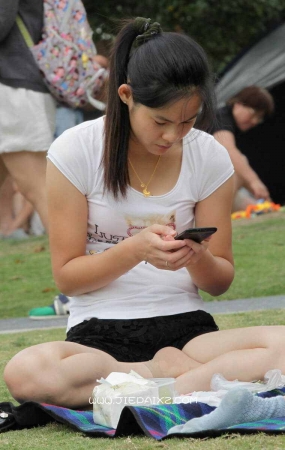 街拍周末草地休闲的短裤短丝年轻妈妈