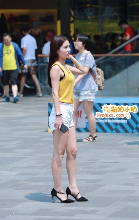 街拍白短热裤无袖黄背心妹子