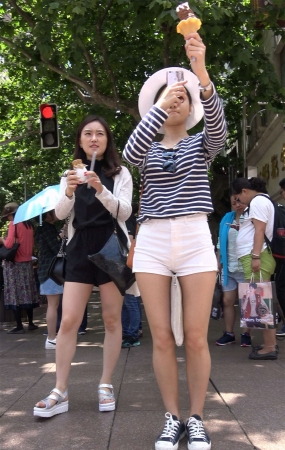 爱摄影的超短热裤太阳帽街拍美女