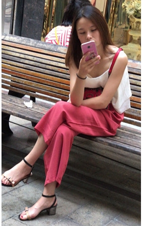 路边玩手机的小妹