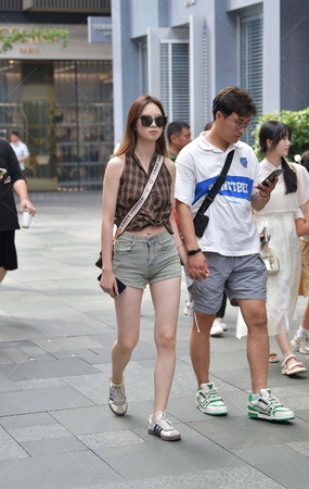 街拍跟男友牵手逛街的热裤小姐姐