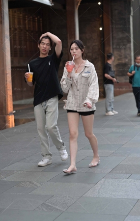 街拍手拿果汁饮料的美腿小姐姐