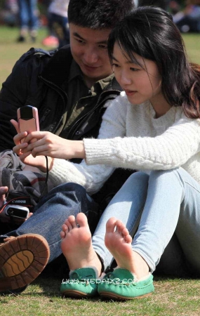 高颜值女孩脱鞋草地上玩自拍